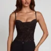 Armelia pyntet topp med cowl-hals og peekaboo-effekt i svart