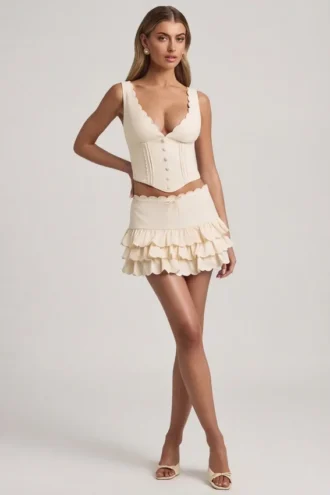 Lorena lagdelt miniskjørt med volanger og lav midje i elfenben