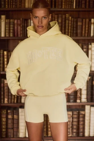 Oversized hettegenser med broderi i myk gul