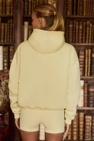 Oversized hettegenser med broderi i myk gul